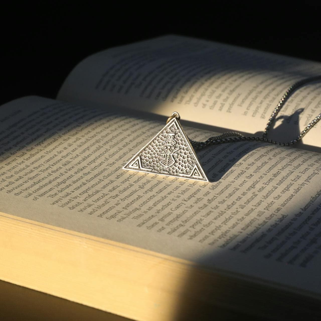Triangle pendant over an open book